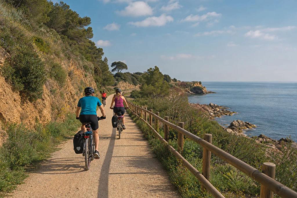 Cyclists riding side by side on a flat, traffic-free greenway on an old railway path outside Barcelona
